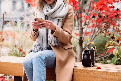 Free Woman texting While sitting on a Bench Stock Photo