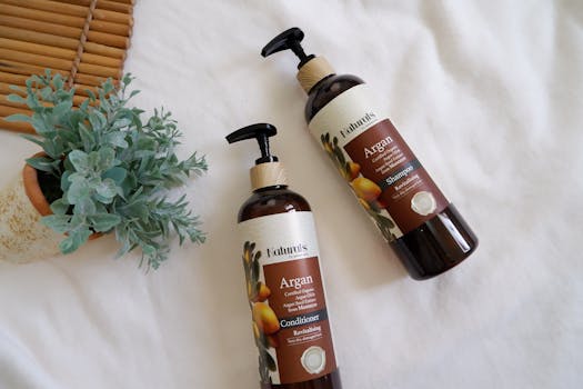 Argan oil shampoo and conditioner set with potted plant on white linen background.