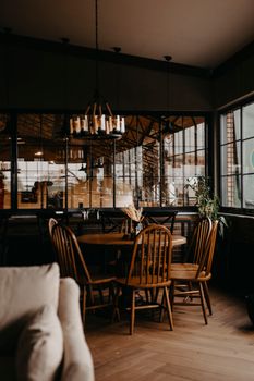 Warm and inviting rustic dining area featuring wooden chairs and a round table beneath a vintage chandelier.