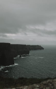 Dramatic view of the Cliffs of Moher under an overcast sky. Perfect for dark, scenic backgrounds.