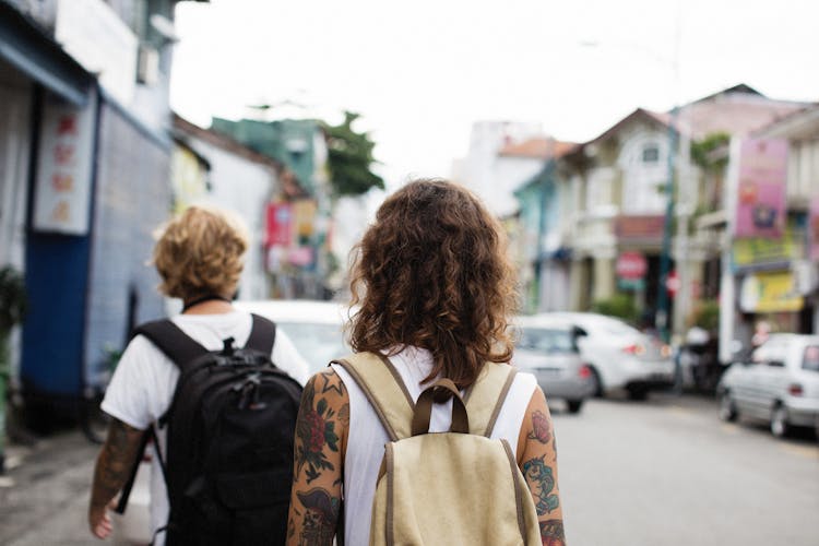 People With Backpacks Walking City Street