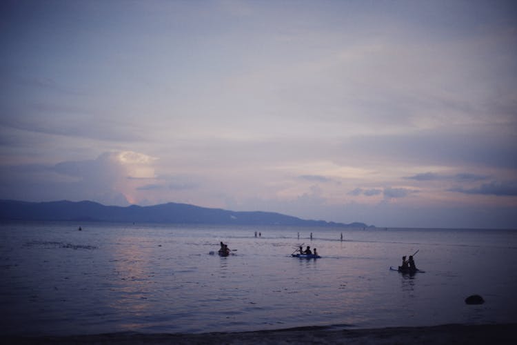 People Canoeing On Sea Shore