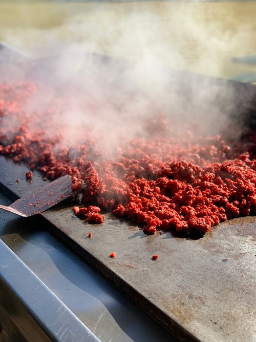 Free Close-up of sizzling ground beef cooking on hot grill with steam rising. Stock Photo