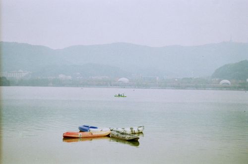 Free Kayaks on a tranquil, foggy lake with distant hills and kayaking duo. Peaceful and serene. Stock Photo