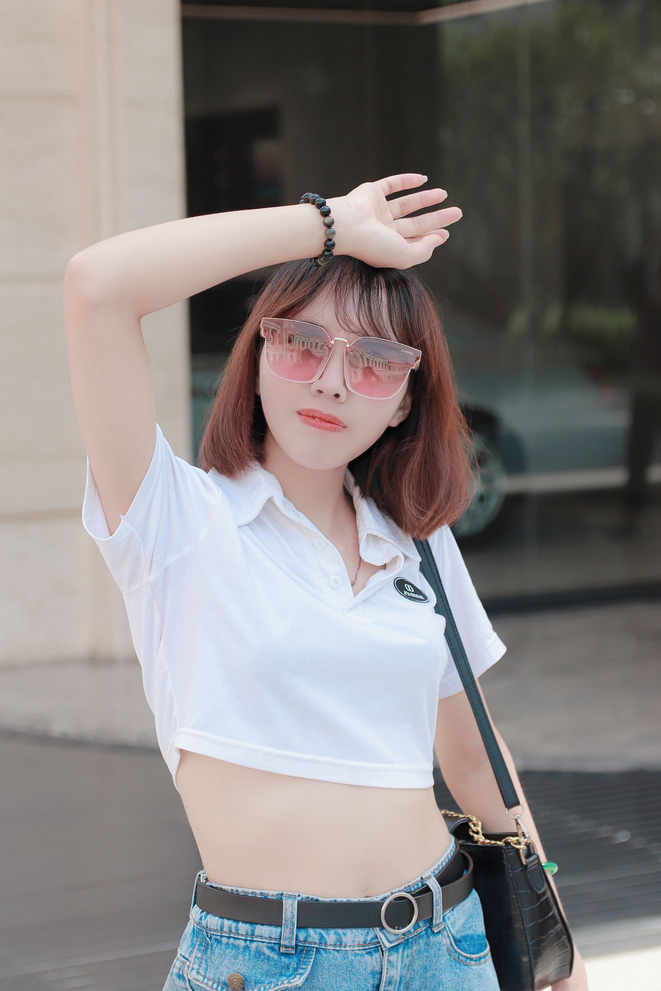 Fashion-forward woman posing with sunglasses in vibrant Hồ Chí Minh City. Perfect blend of style and modern street fashion.