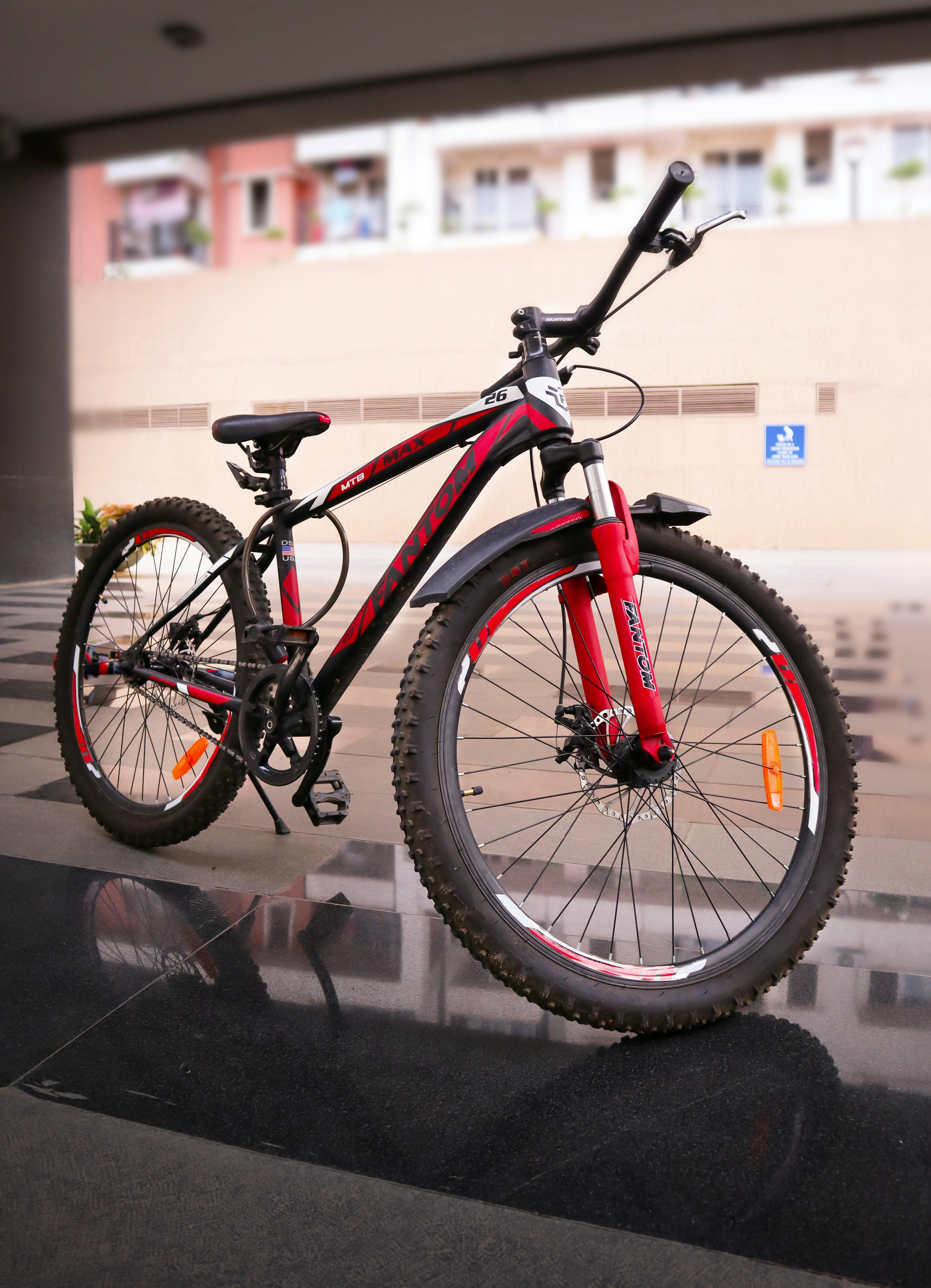 A modern red and black mountain bike parked indoors showcasing its sturdy frame and design.