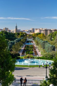 Scenic view of a park fountain in Zaragoza, Spain, showcasing vibrant greenery and urban skyline.