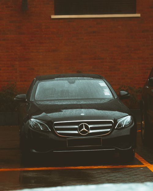 Free A sleek Mercedes Benz parked in Nairobi, Kenya, under soft rain, highlighting its luxury and elegance. Stock Photo