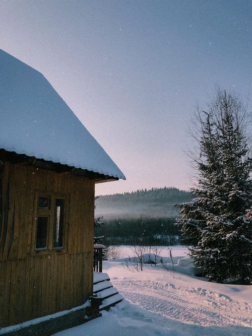 Free A cozy wooden cabin sits peacefully in a snow-covered winter wonderland. Stock Photo