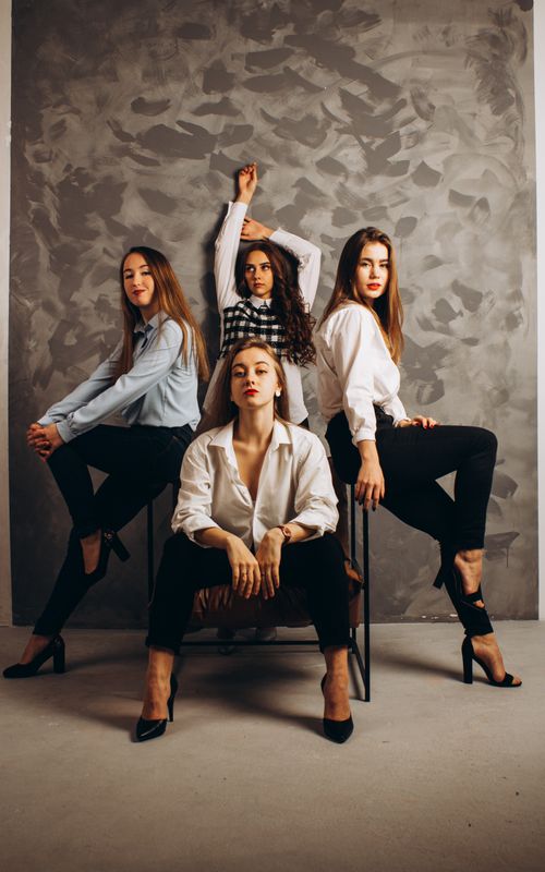 Free Four fashionable women posing confidently in a stylish studio setting. Stock Photo