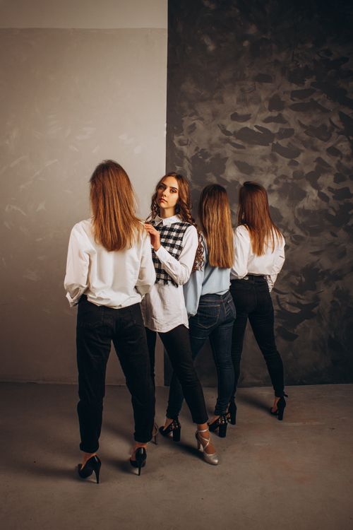 Free Four women standing in a studio, showcasing a stylish and artistic composition with a textured backdrop. Stock Photo