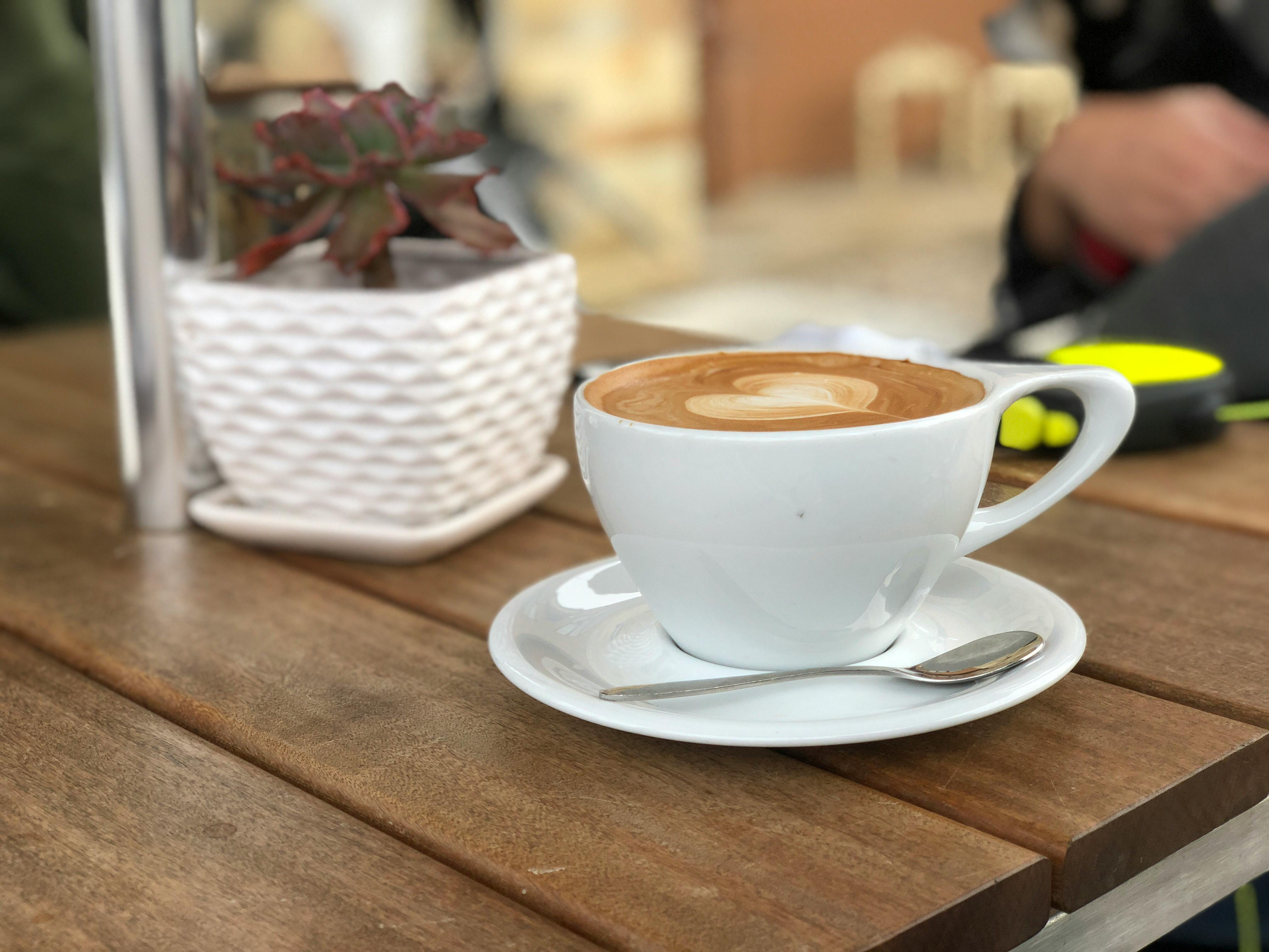 white ceramic coffee mug with saucer and teaspoon