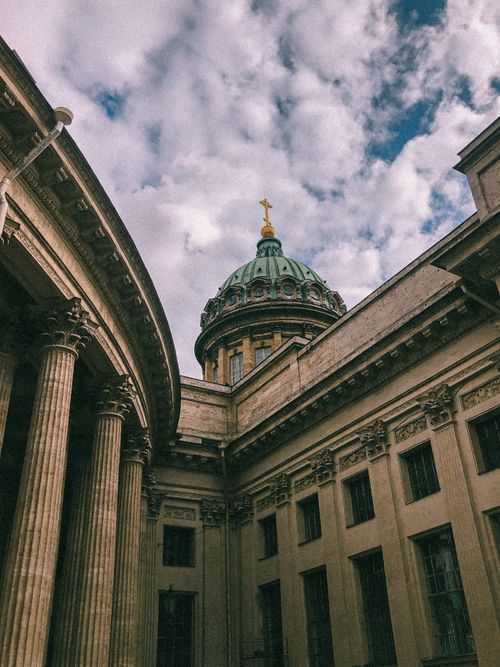 Free A majestic cathedral dome and columns under a dramatic cloudy sky, showcasing classic architecture. Stock Photo