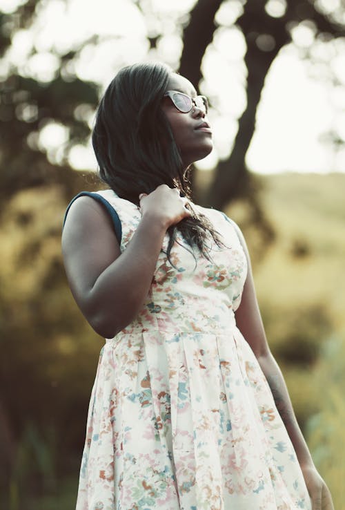 Mujer Con Vestido Floral Blanco Y Beige Sosteniendo Su Cabello