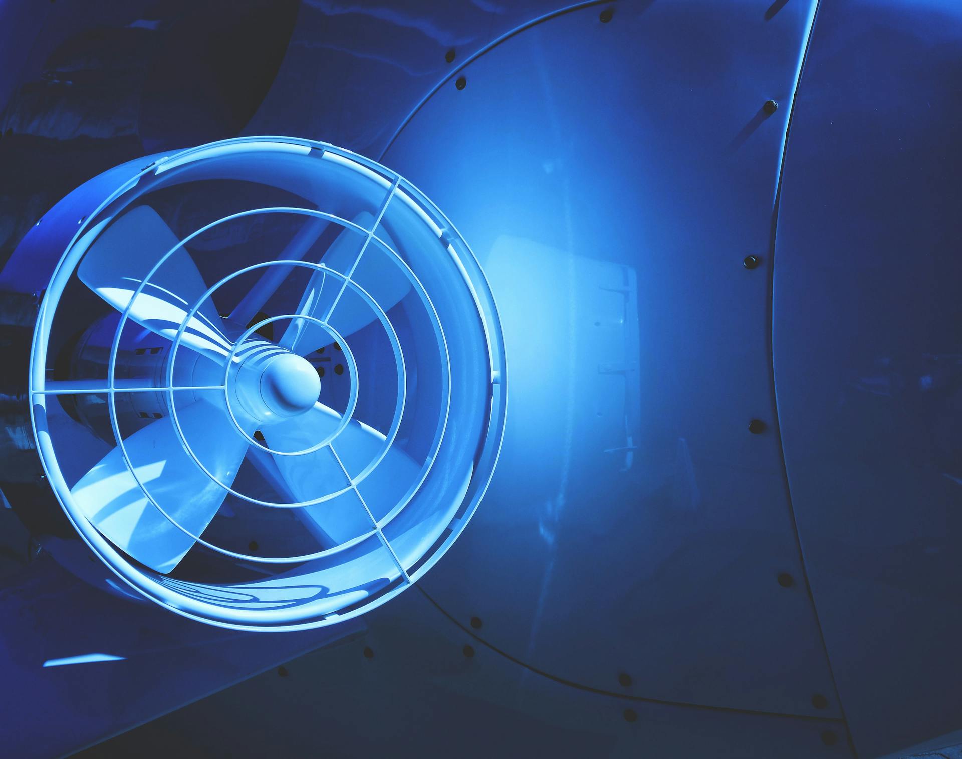 A close-up view of a blue illuminated jet engine turbine showcasing modern aviation technology.