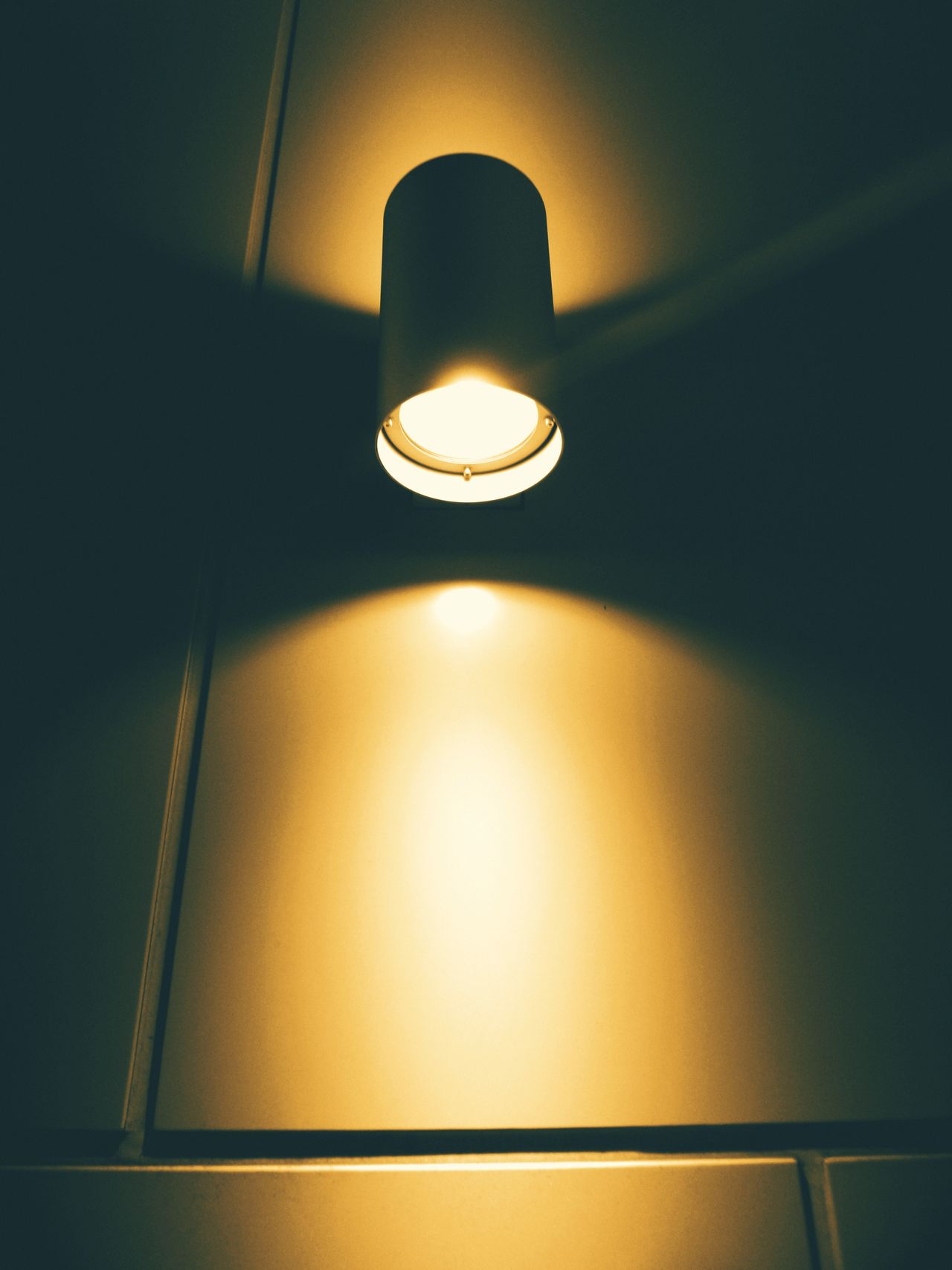 Cylinder spotlight glowing warm on a dark ceiling