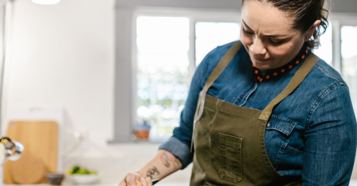 Woman Using Cooker in Domestic Kitchen · Free Stock Photo