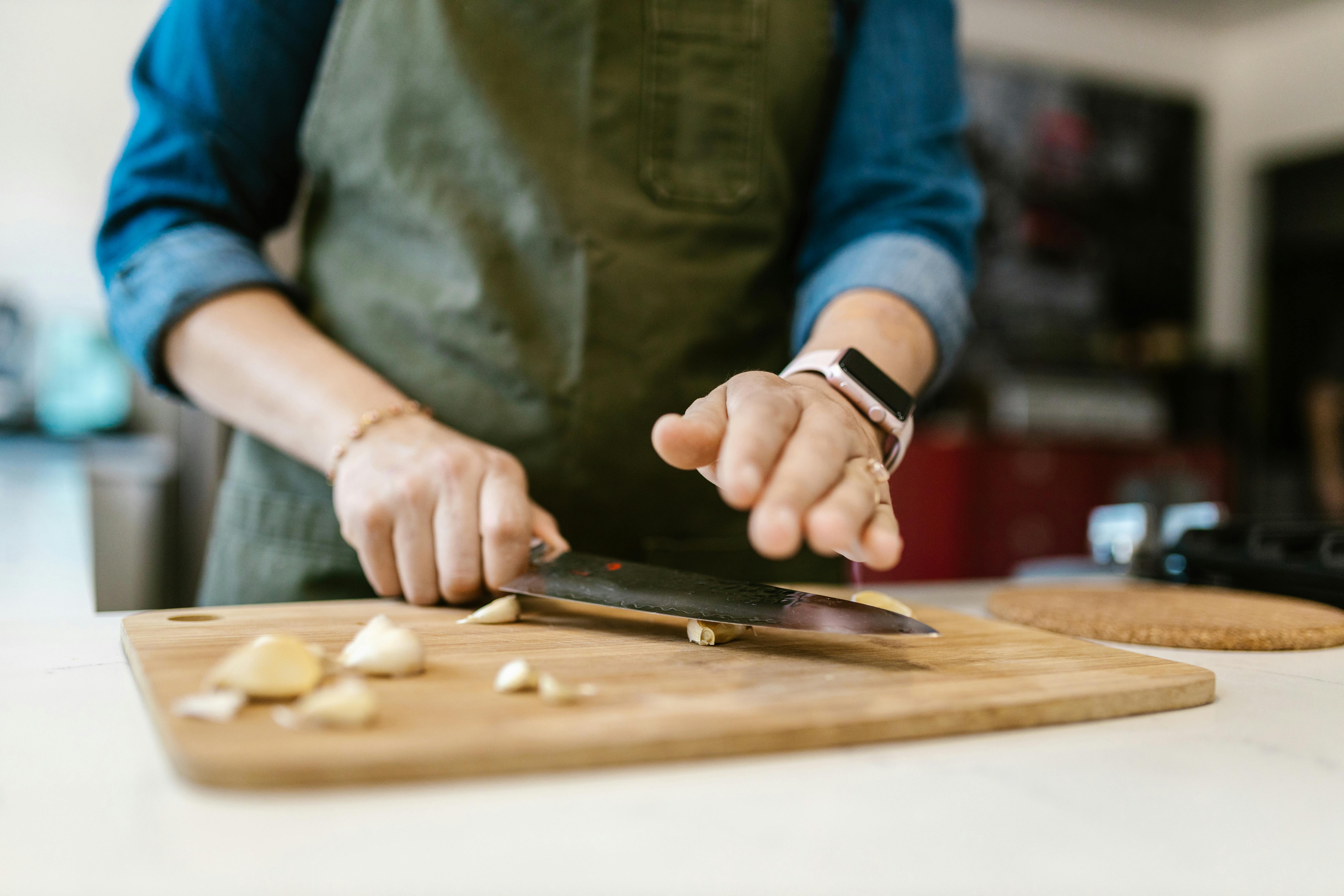 Woman Crushing Garlic with Knife · Free Stock Photo