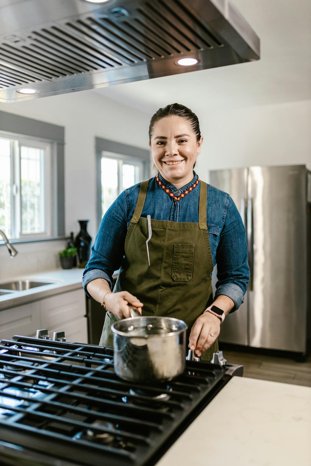 Smiling woman cooking a meal on a stove in a modern kitchen
