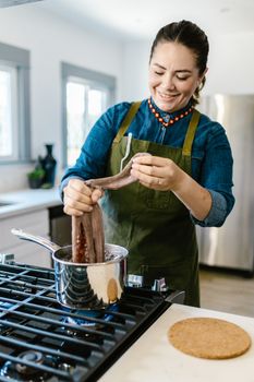 Woman skillfully cooks octopus in a stylish kitchen setting, showcasing culinary expertise.