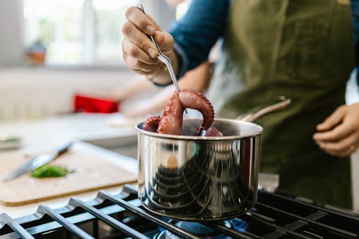 Close-up of a chef cooking octopus in a modern kitchen setting.