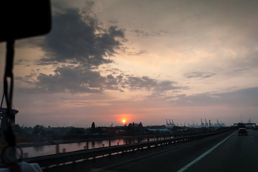 日落时分，高速公路旁工业天际线耸立，云层格外引人注目