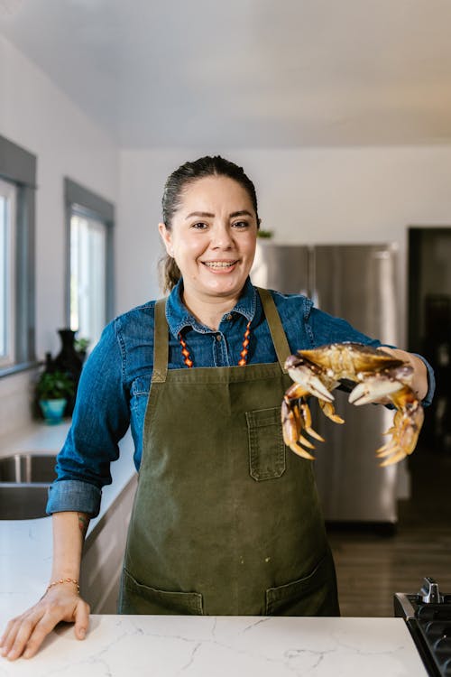 Woman Holding Lobster in Kitchen