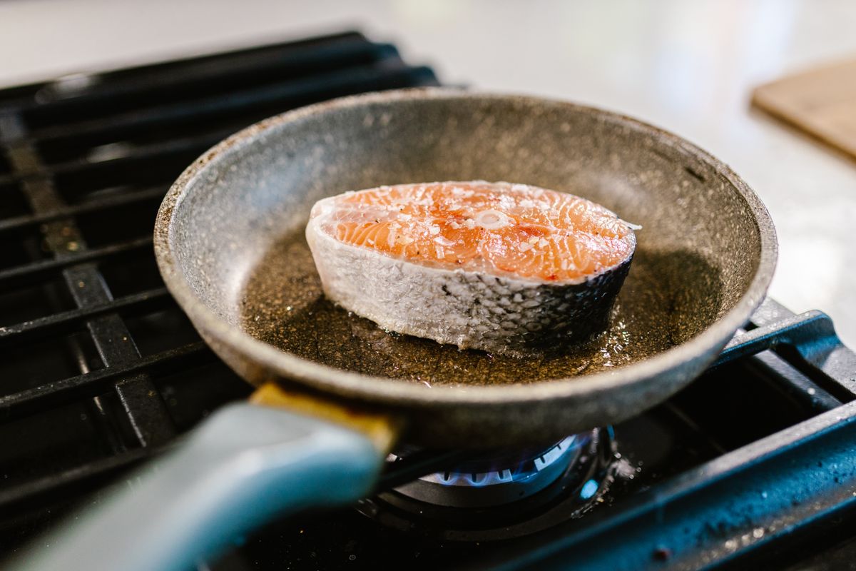 A salmon steak searing in an iron frying pan — photo by RDNE Stock project on Pexels