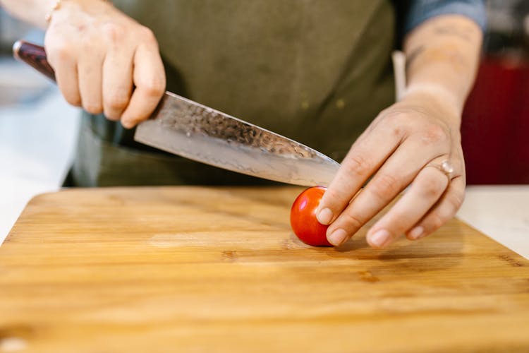 Chef Cutting Tomato On Cutting Board