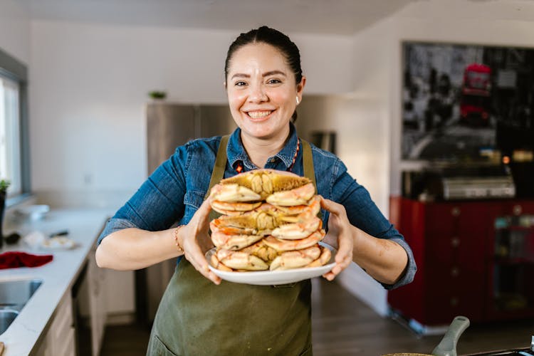 A Chef Holding A Plate Of Stacked Crabs