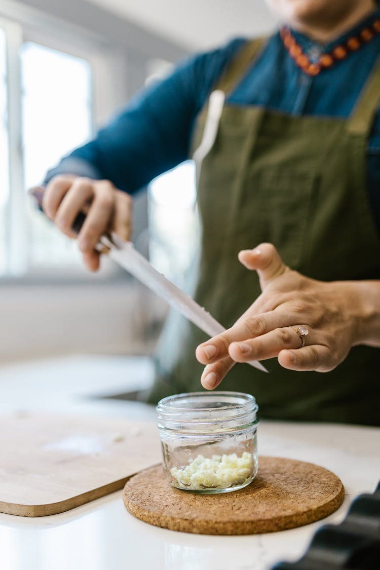 Chef Holding Knife Over Glass Jar