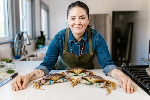 A cheerful chef in a modern kitchen showcases fresh crabs on a marble countertop.