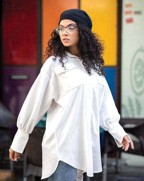 Free Chic portrait of a woman with curly hair wearing eyeglasses and a headscarf, looking over her shoulder. Stock Photo