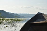 Brown Boat on Lake Near Green Trees and Mountains