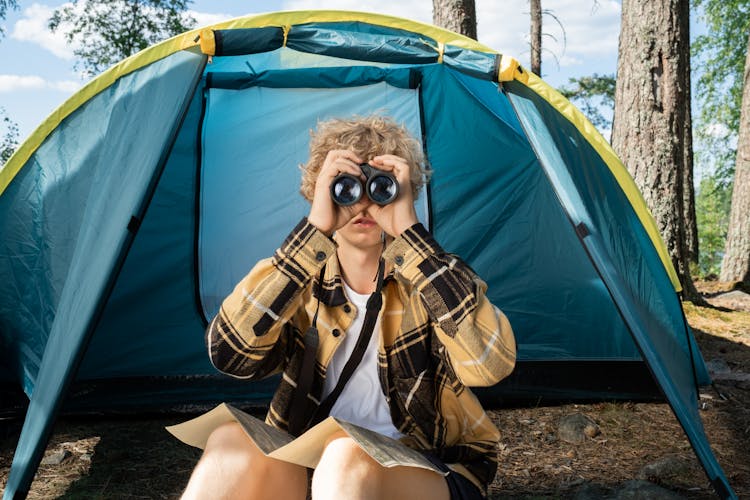 A Teenager Looking Through The Binoculars