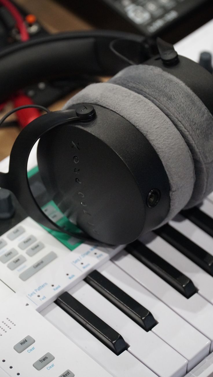 Close-up of professional headphones resting on a keyboard, showcasing audio technology.