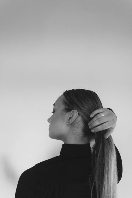 Elegant black and white portrait of a woman with long hair held back.