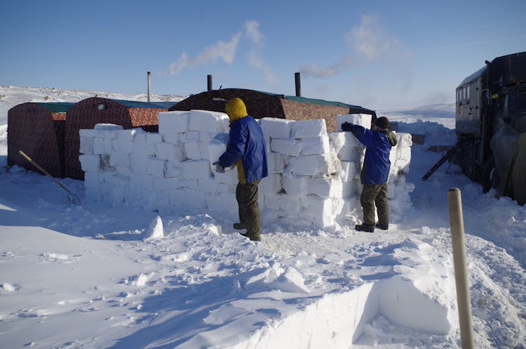 Men Stacking Blocks Of Snow 