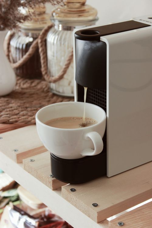 Free Close-up of a coffee machine brewing a fresh cup indoors on a wooden shelf. Stock Photo