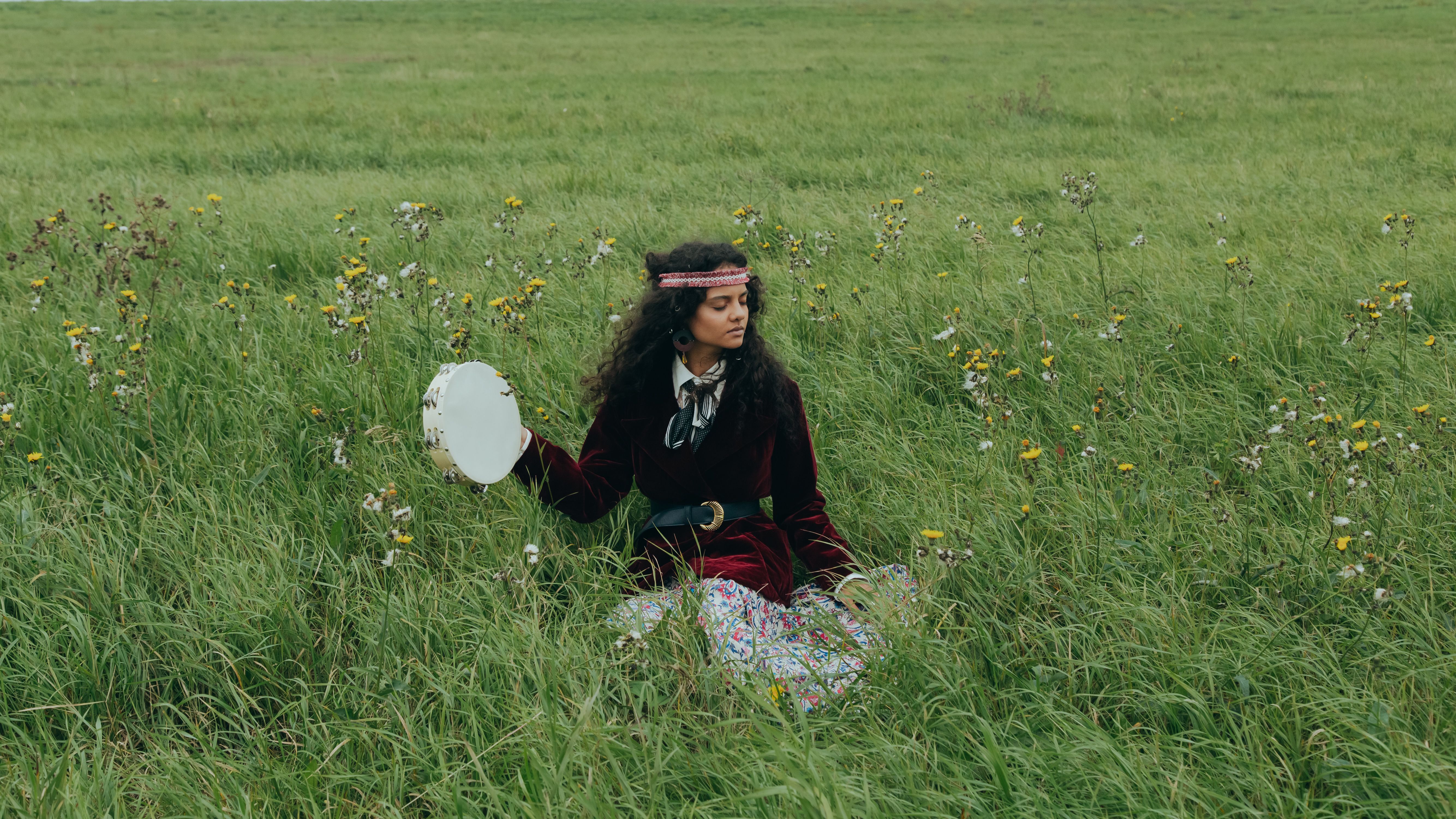 A Woman Sitting on Green Grass Field · Free Stock Photo