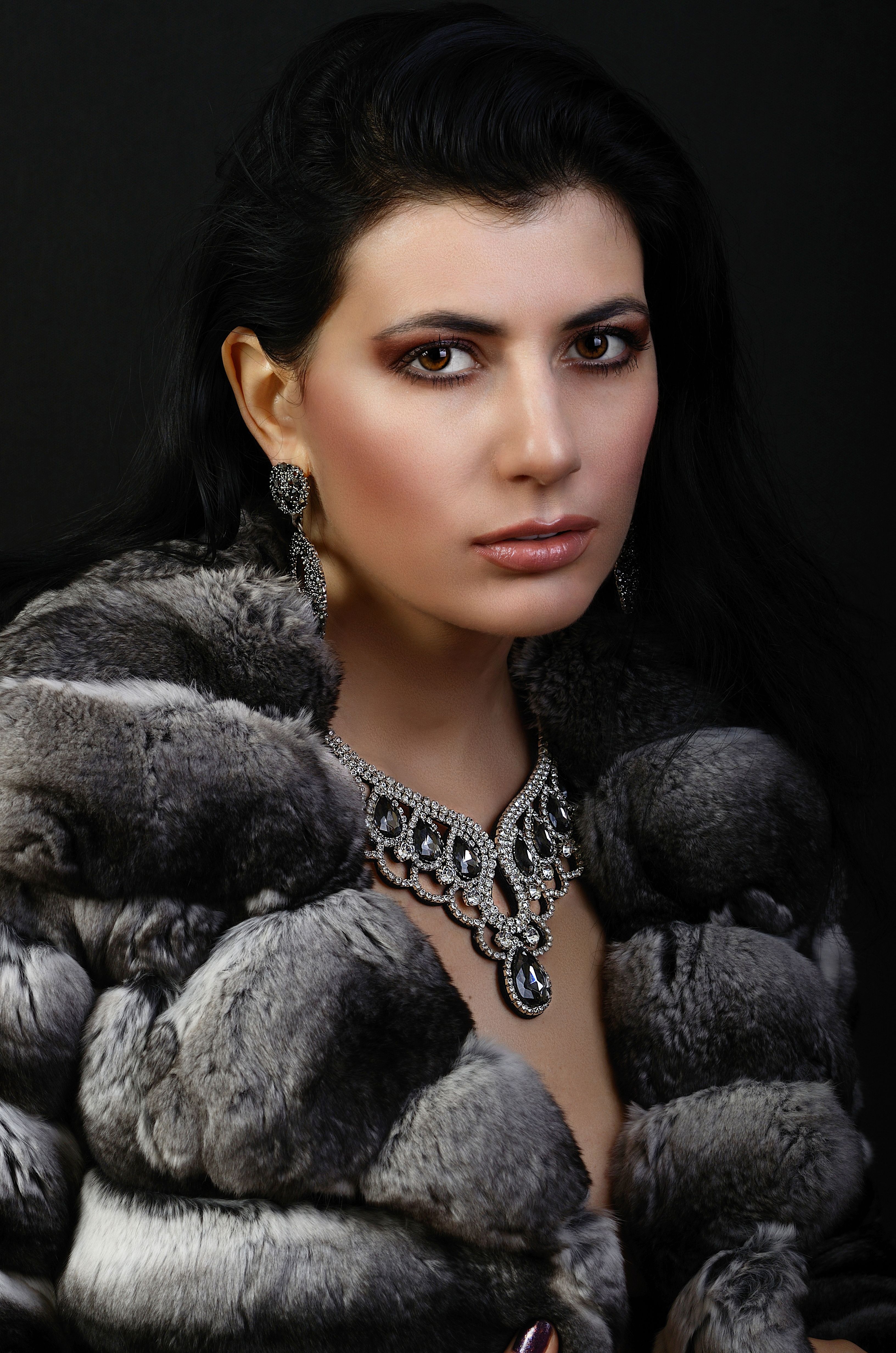 Portrait of an elegant woman in a fur coat, adorned with luxurious jewelry.