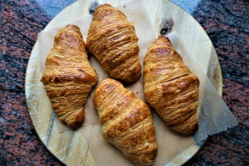 Free Delicious golden croissants on a wooden board, perfect for breakfast or brunch. Stock Photo