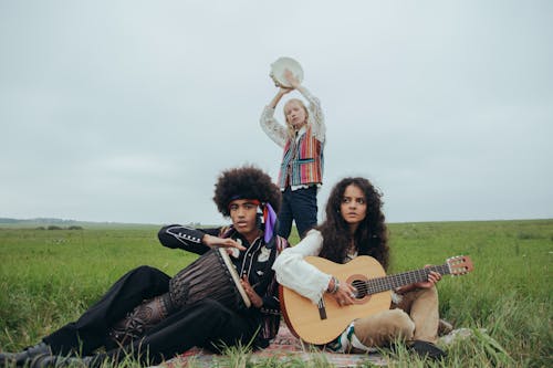 People Playing Instruments on Green Grass Field