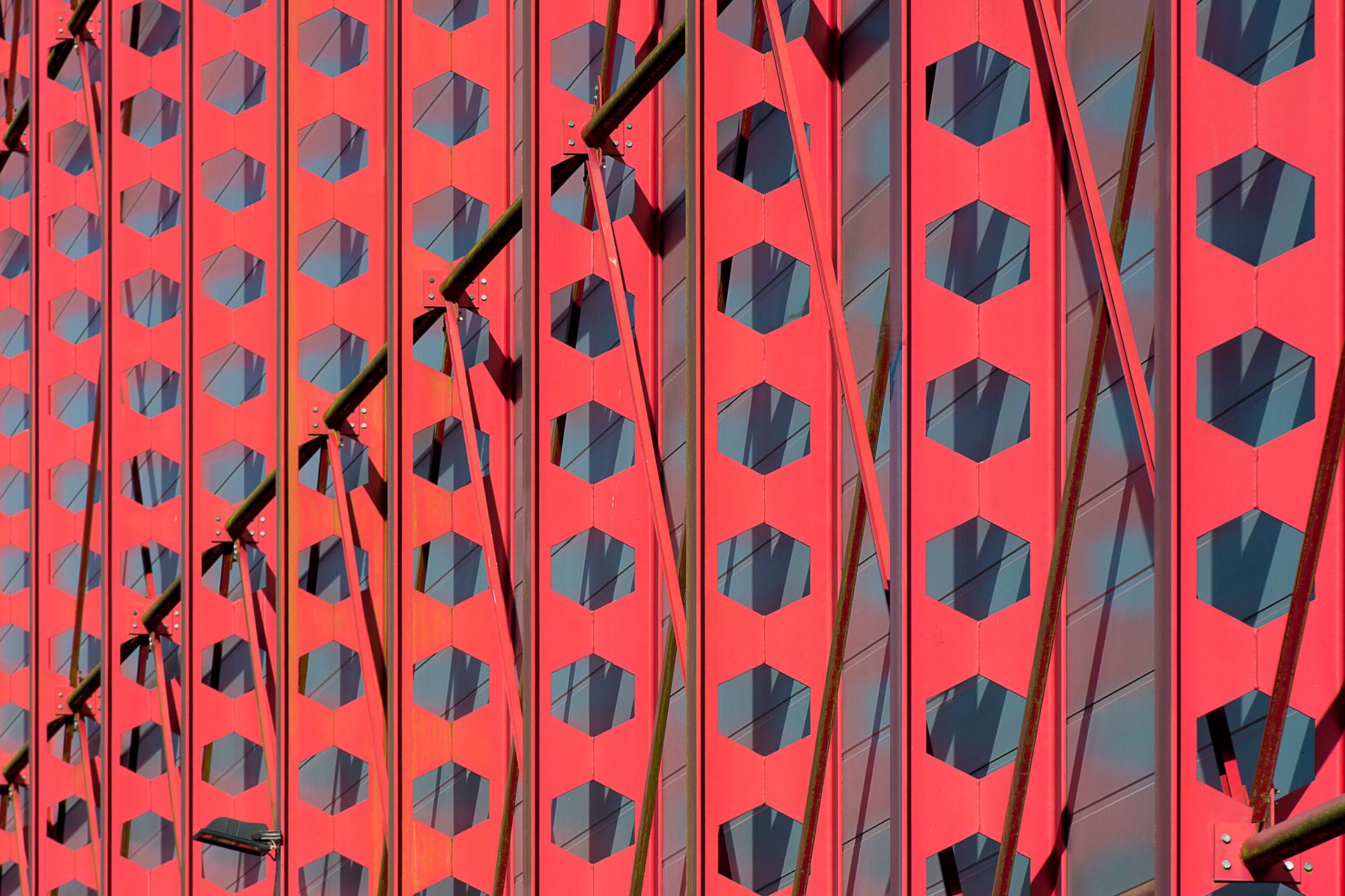 Close-up of a red facade with geometric patterns and steel frames showcasing modern architecture.