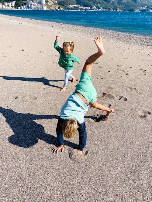 Children Playing on Beach Sand on Shore