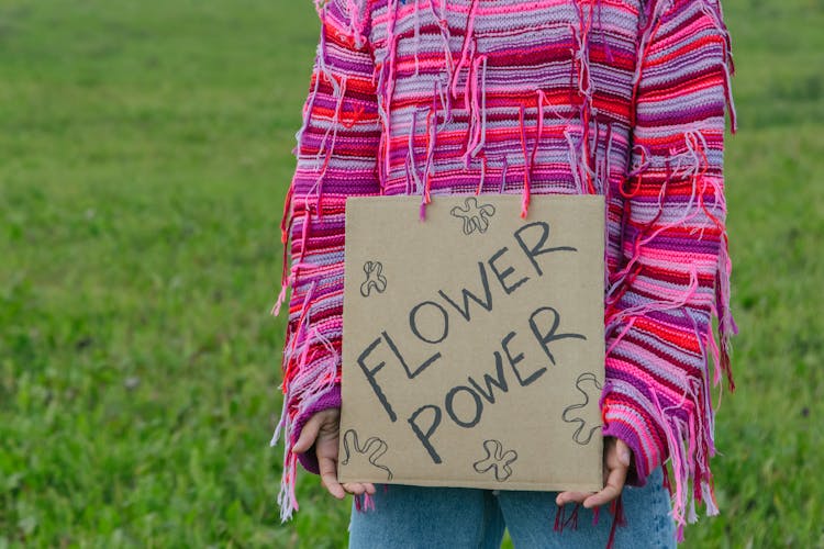 A Protester In A Pink Sweater Holding A Placard