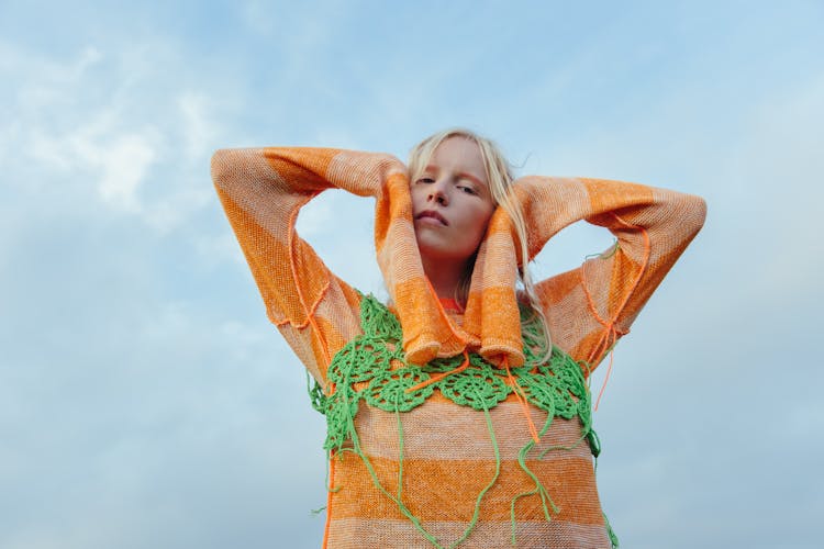 A Woman In Orange Knit Sweater And Green Crochet Top