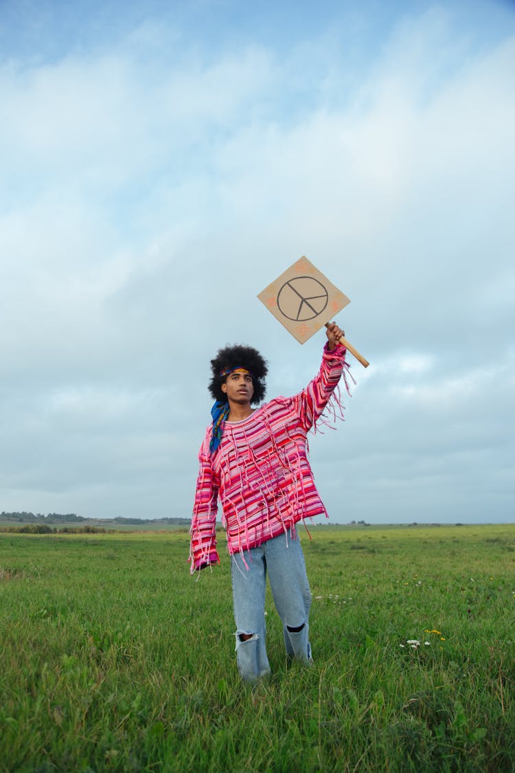 A Man Holding A Peace Sign Placard