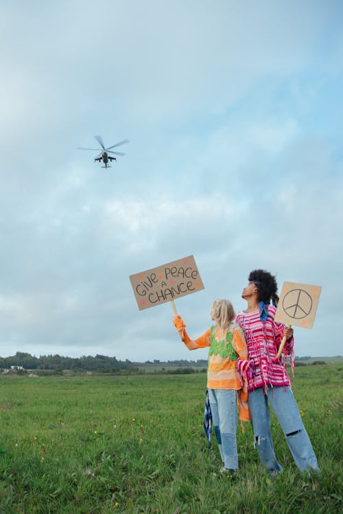 A Helicopter Flying Over a Couple Holding Placards