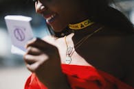 一位微笑的女人在户外优雅地展示珠宝，佩戴着以警告为主题的项链